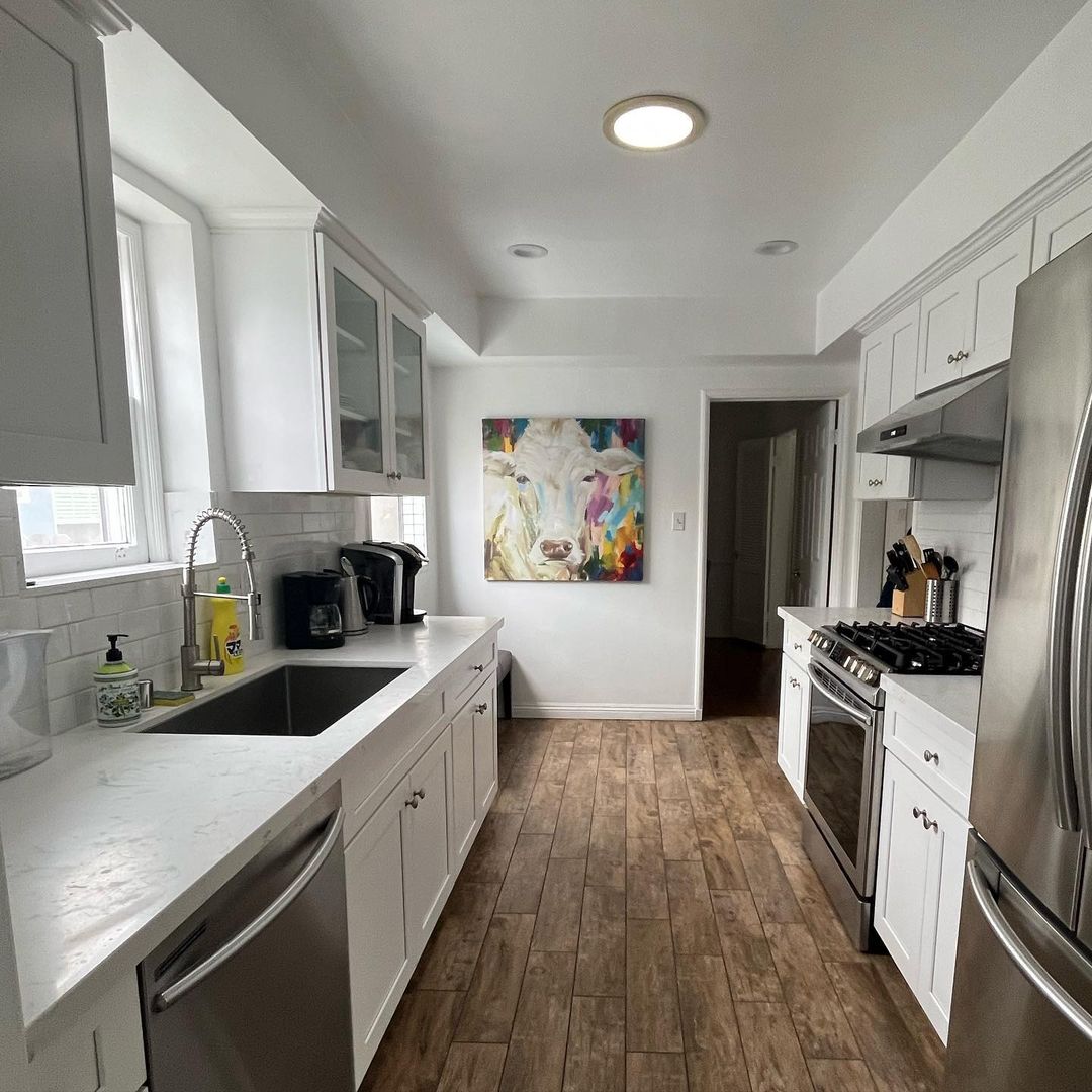 White Cabinets And Wooden Flooring Galley Kitchen