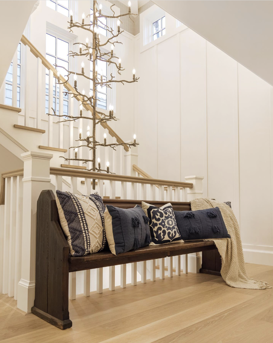 A royal sofa with an overhanging chandelier that looks like an old branch of a tree but golden.