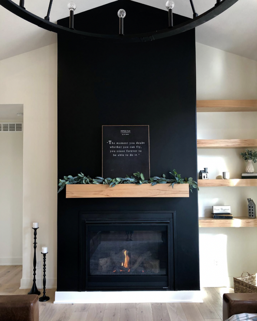 Black Painted Fireplace With Wooden Floating Shelves On One Side