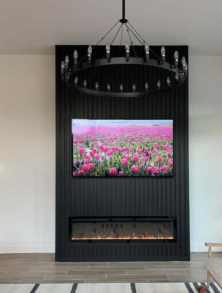 Black TV Stand With Floor-To-Ceiling Fireplace And Hanging Candelier
