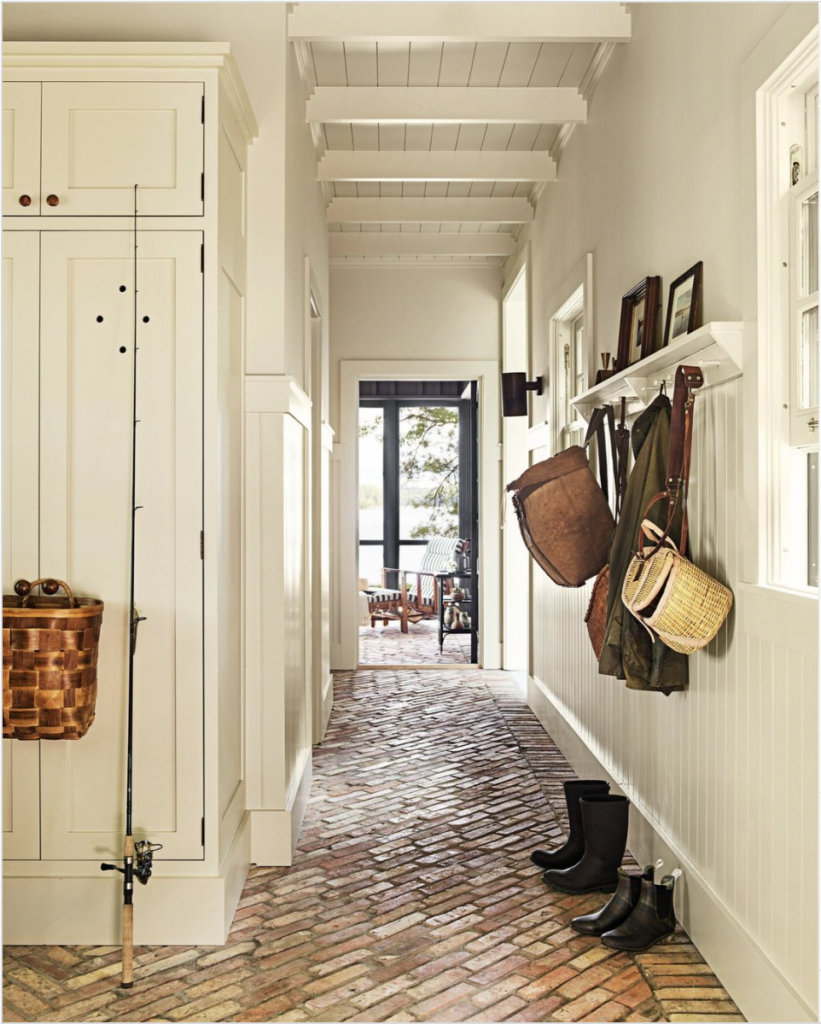 Farmhouse Hallway With Red Brick Flooring And White Wall Trimming