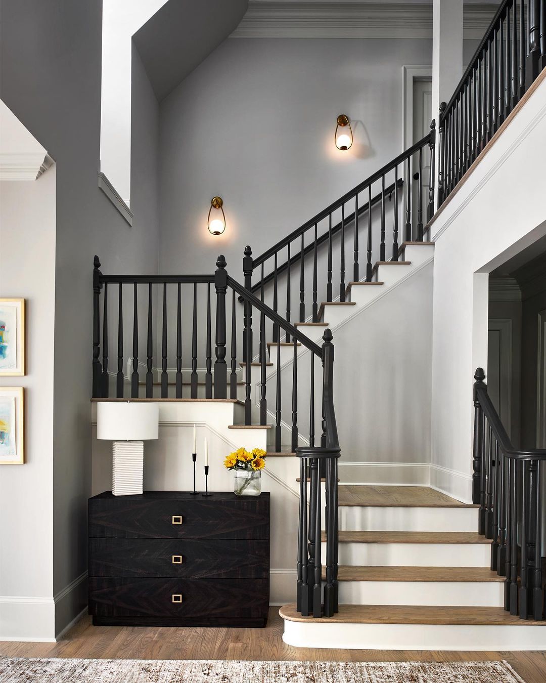 The contrast of back and white with stone color for the staircase landing design.