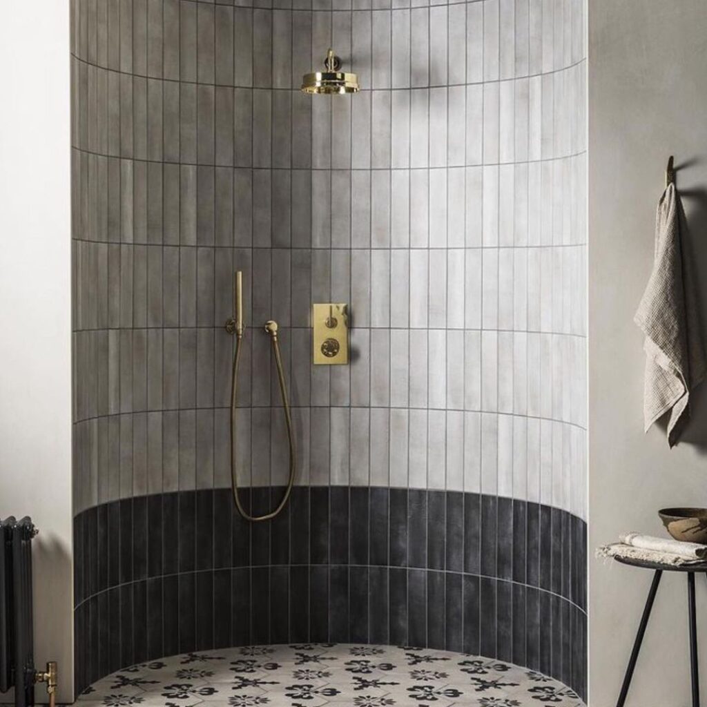 Light Grey Vertical Accent Tile In Shower With Gold Hardware