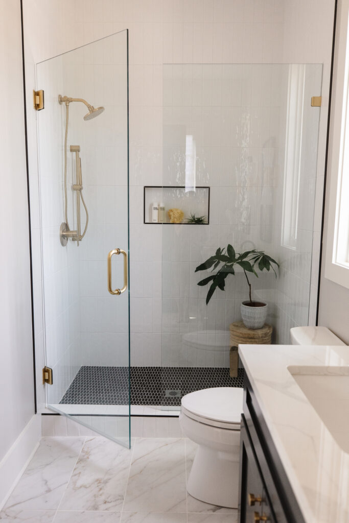 White Vertical Accent Tiles In Shower With Black Flooring
