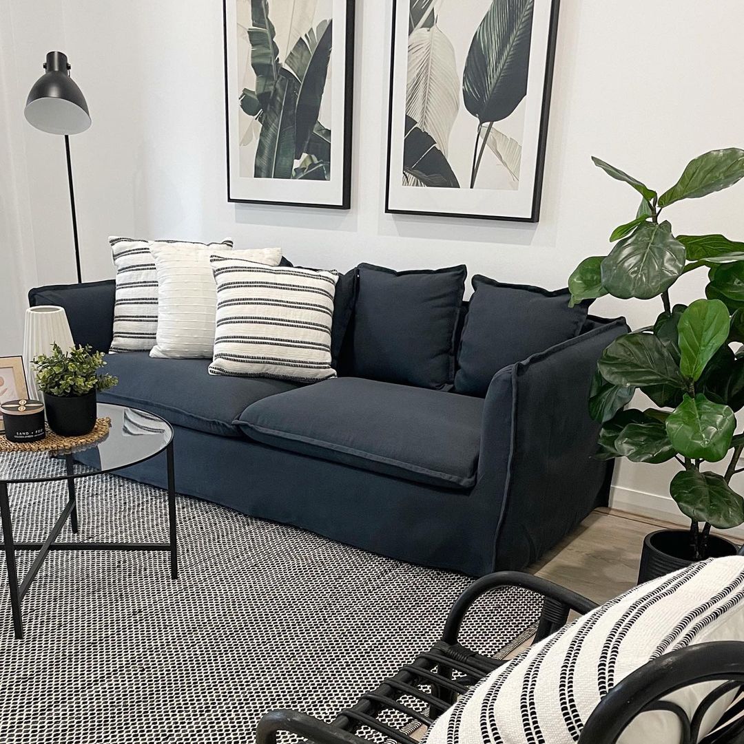 Black Couch with Natural Accents and Monochrome Art