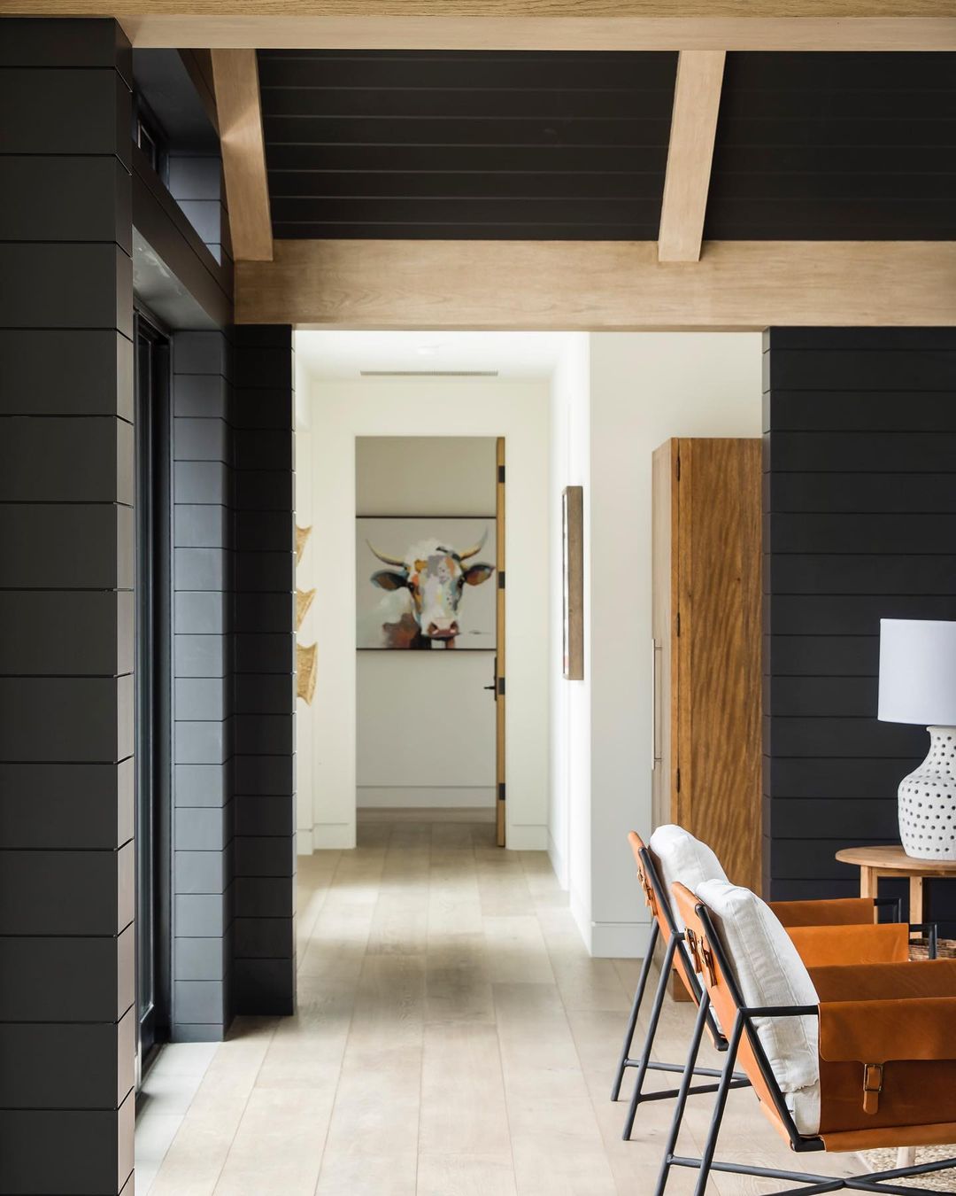 Dark Accents and Light Wood Beams for a Striking Hallway
