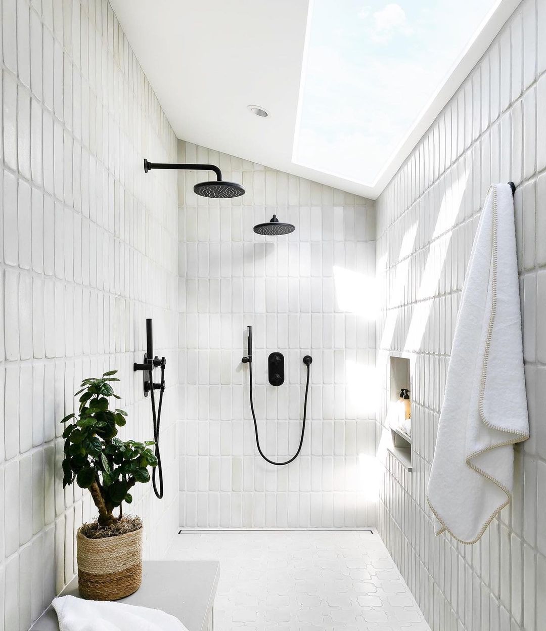 Bright Skylit Shower with White Tile Pan and Black Fixtures