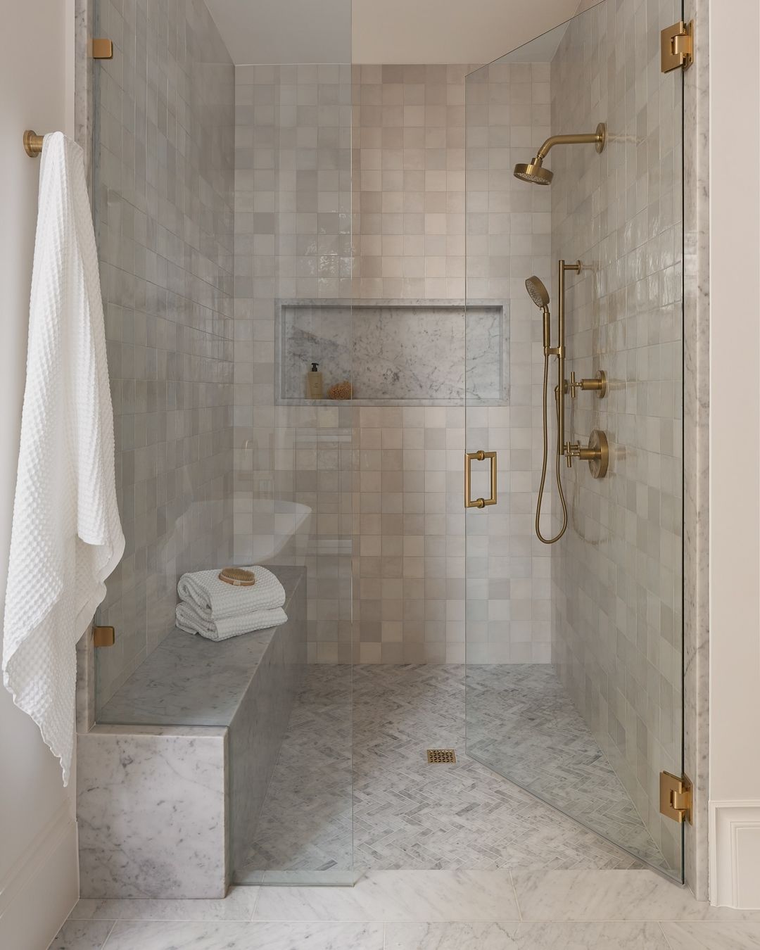 Luxurious Marble Shower with Bench and Brass Fixtures
