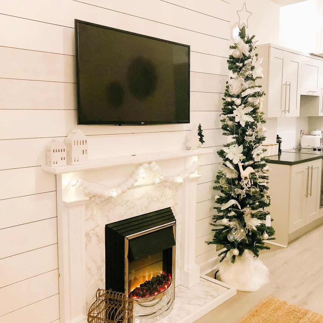 Enhance Your Fireplace Area with a Slim Christmas Tree and Winter White Decor