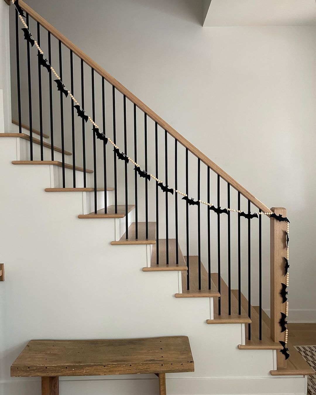 19. Minimalist Halloween Staircase with Bat and Bead Garland