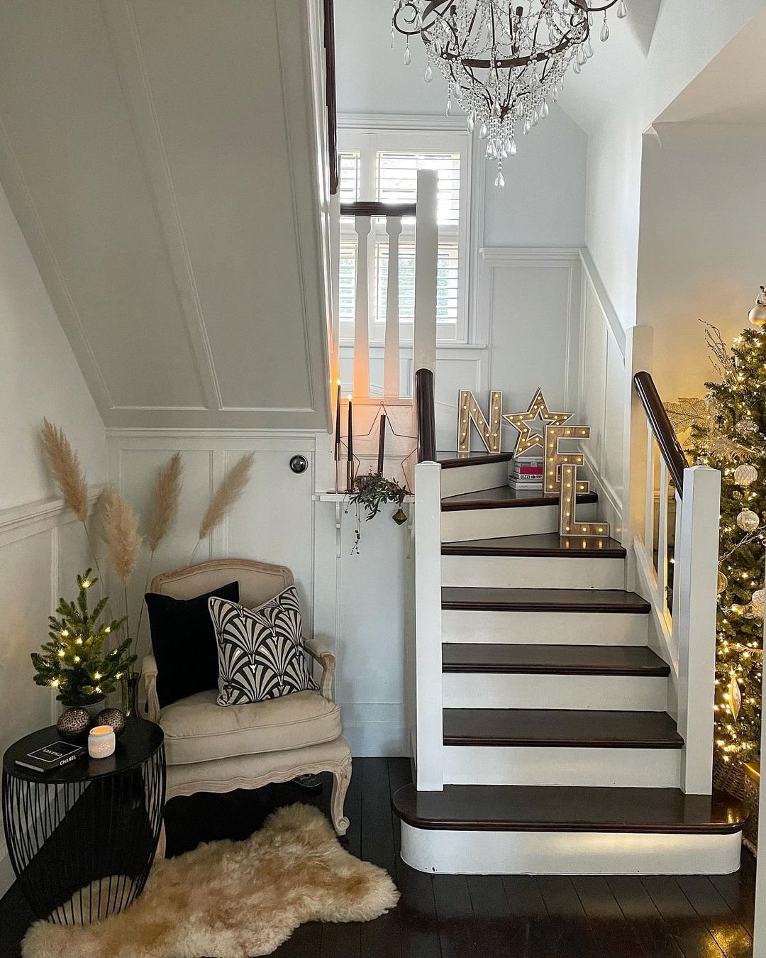 Cozy Staircase Nook with Lit ‘Noel’ Sign for a Warm Holiday Welcome