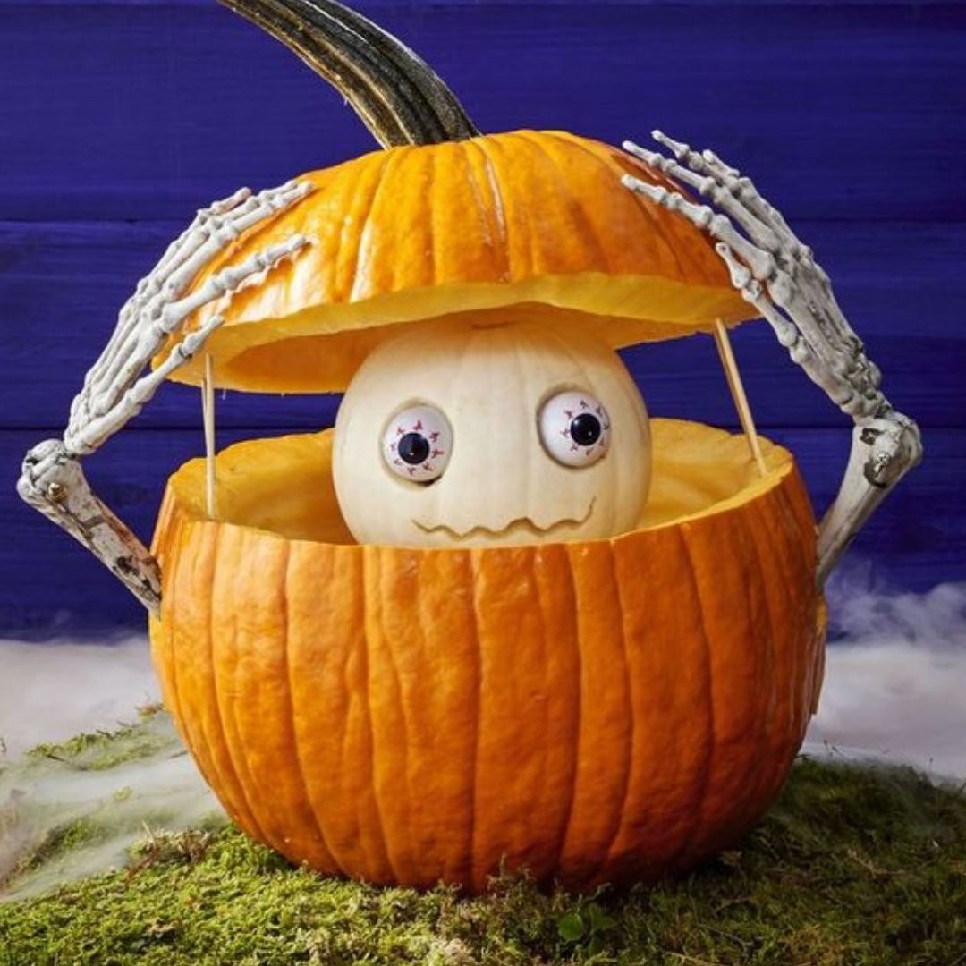 Peekaboo Pumpkin with Spooky Skeleton Hands for a Playful Halloween Surprise