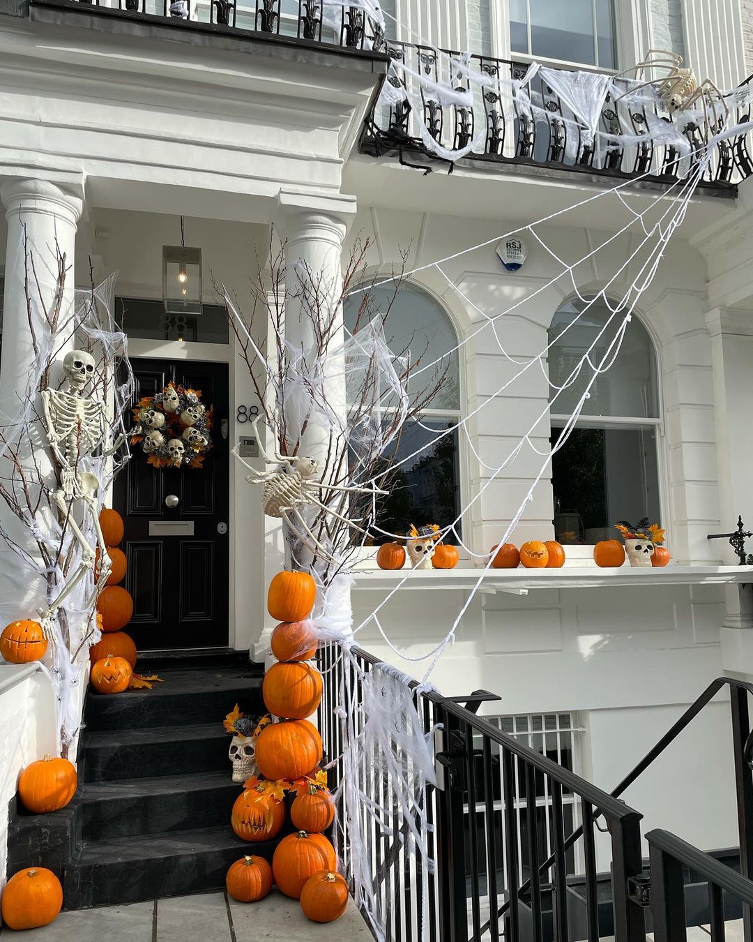 Grand Halloween Entrance with Skeletons and Webbed Pumpkins