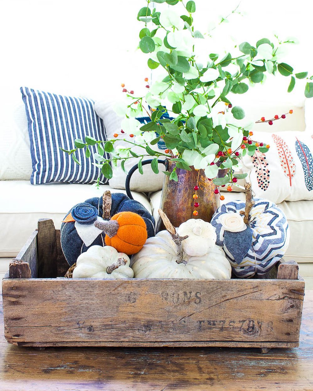 Add a Rustic Touch to Your Living Room with a Wooden Crate of Pumpkins and Greenery